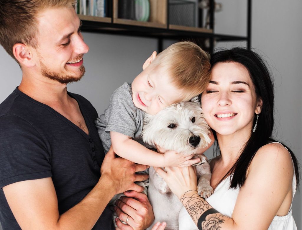 adorable family hugging their dog