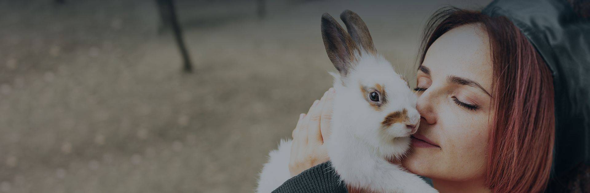 woman kissing a white rabbit